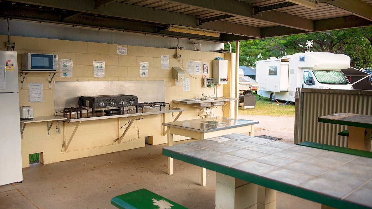Camp kitchen includes seating, refrigeration, cooking and sink facilities.