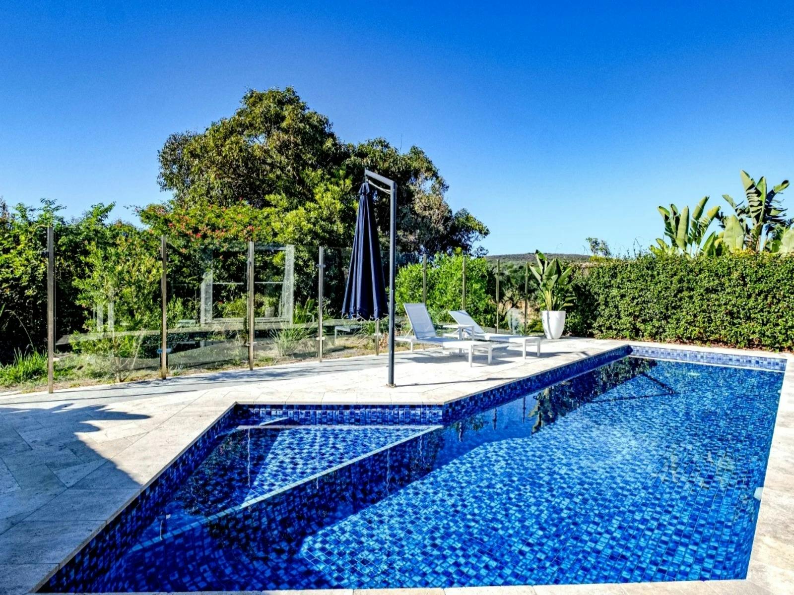 Resort-style pool area with sun lounges, adjustable umbrella, and provided pool towels