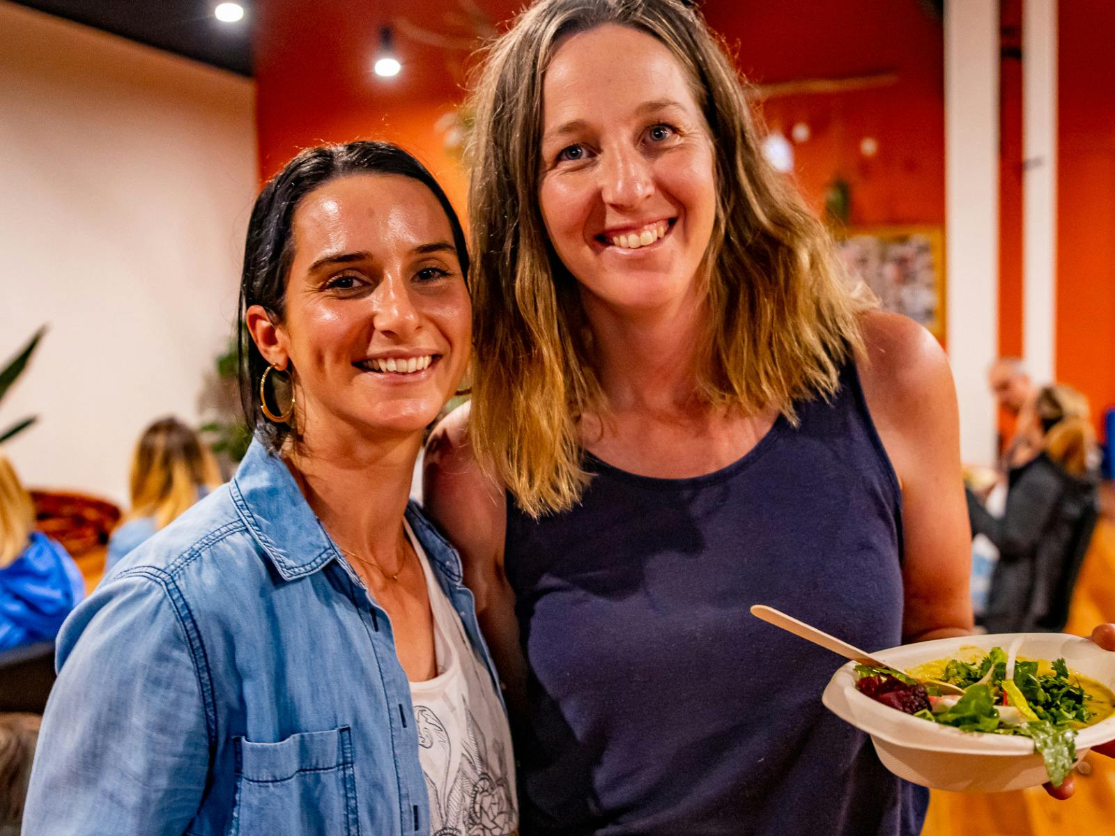 Two women smiling while eating lunch