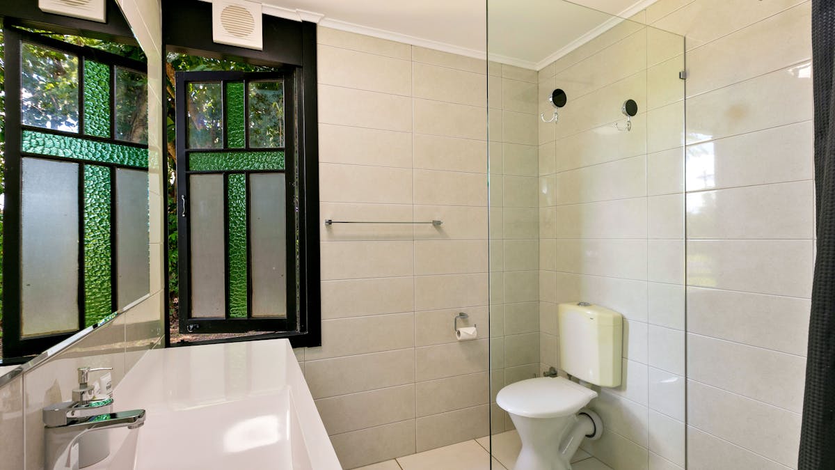 Interior bathroom. Toilet, shower, basin, stained glass windows. Accessible bathroom.