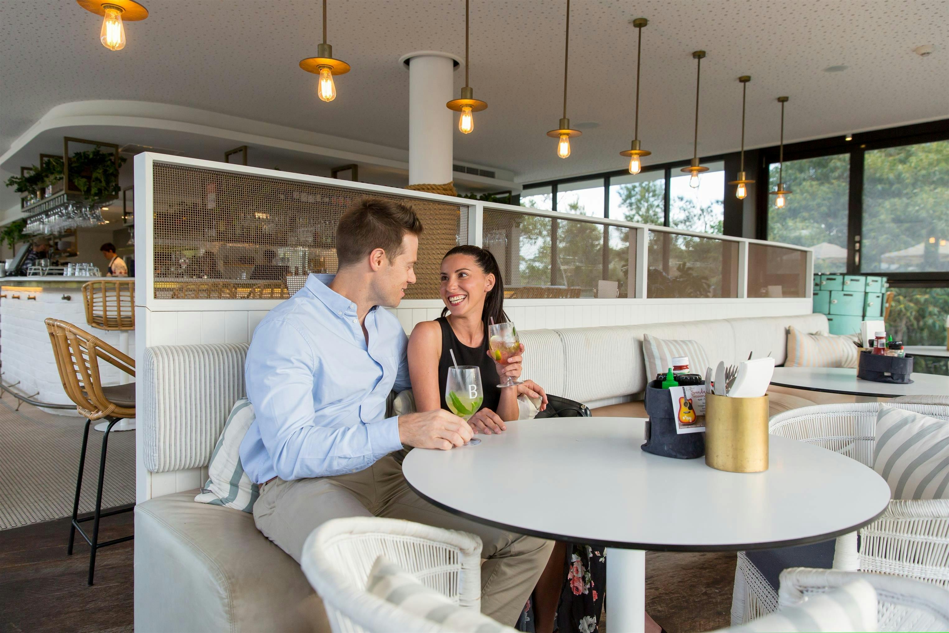 Seated couple enjoying a cocktail in a restaurant