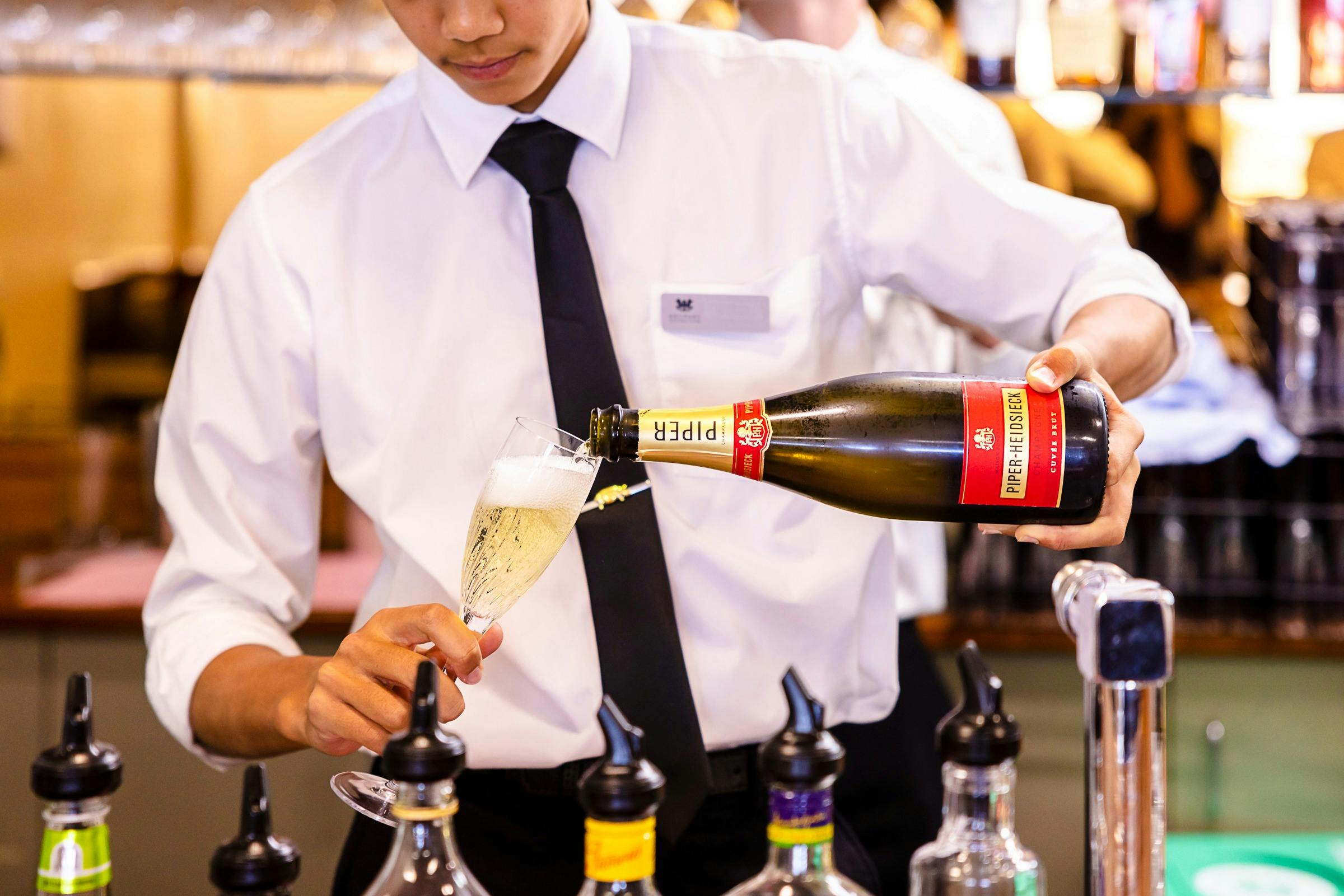 A person pouring a glass of sparkling wine