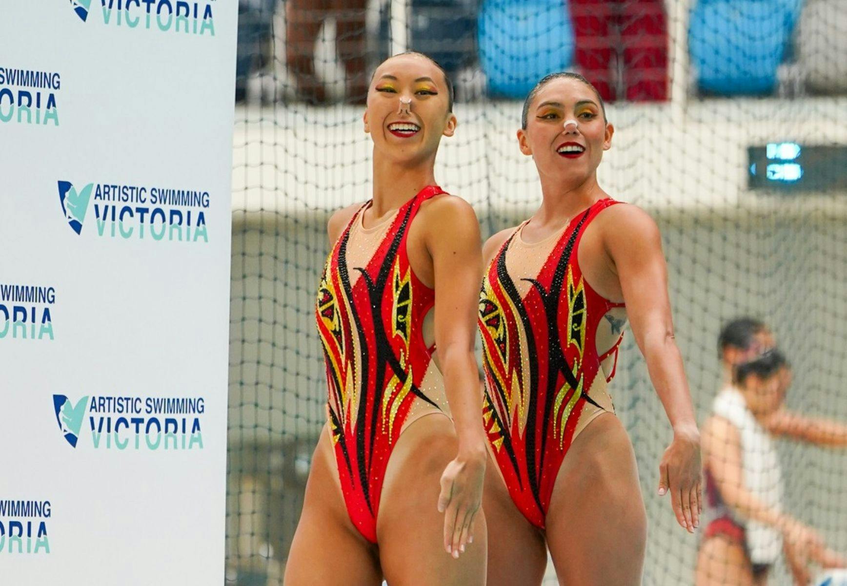 two artistic swimmers smiling and posing