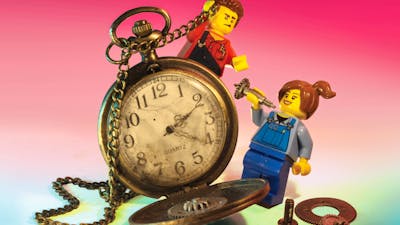 RELICS hero image featuring two miniature lego figures interacting with vintage stopwatch