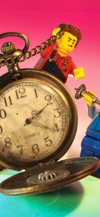 RELICS hero image featuring two miniature lego figures interacting with vintage stopwatch