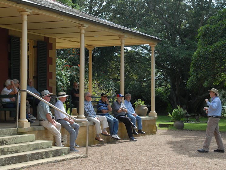 Tour guide and group outside homestead