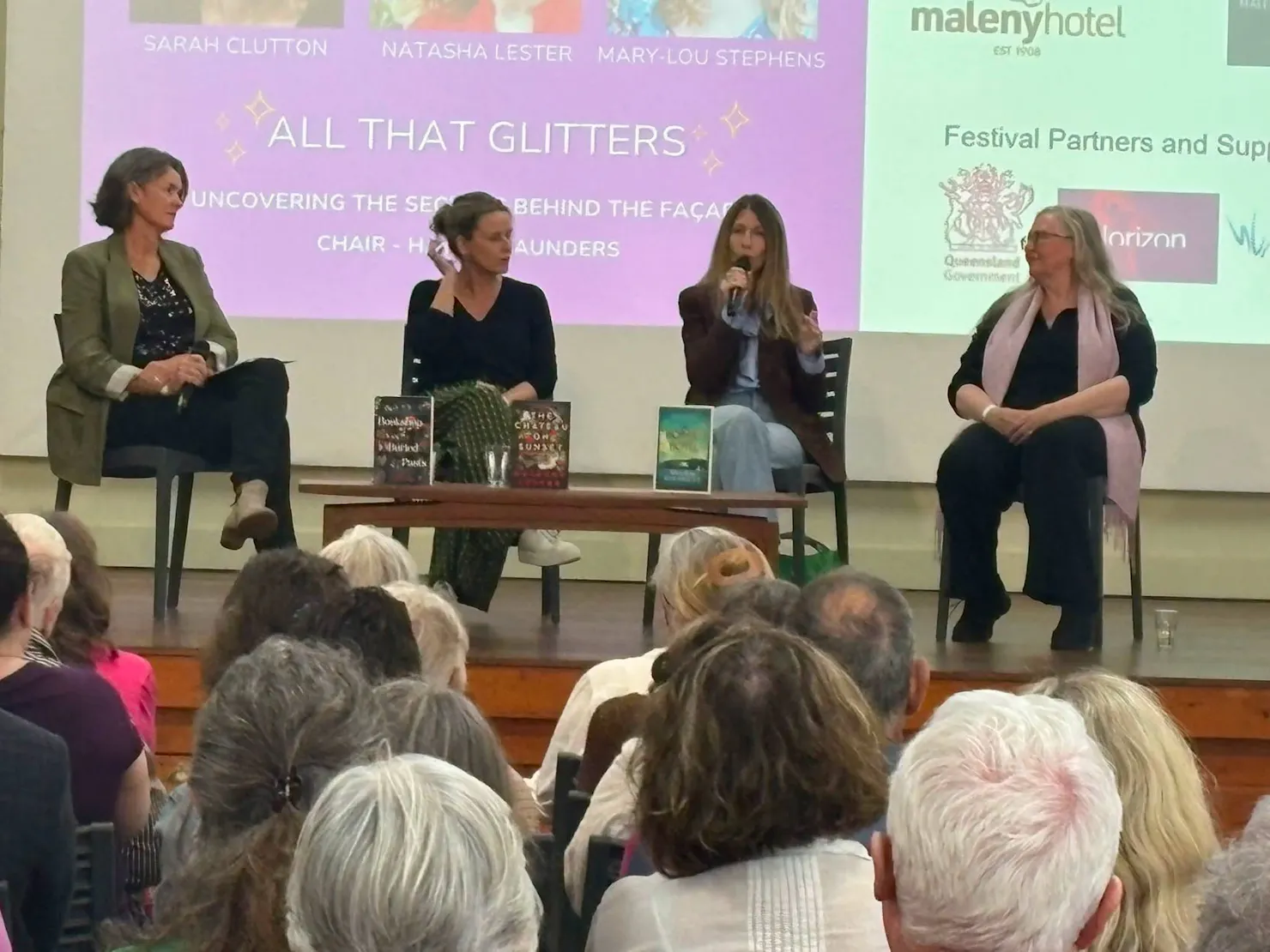 A panel of authors being interviewed in front of a crowd