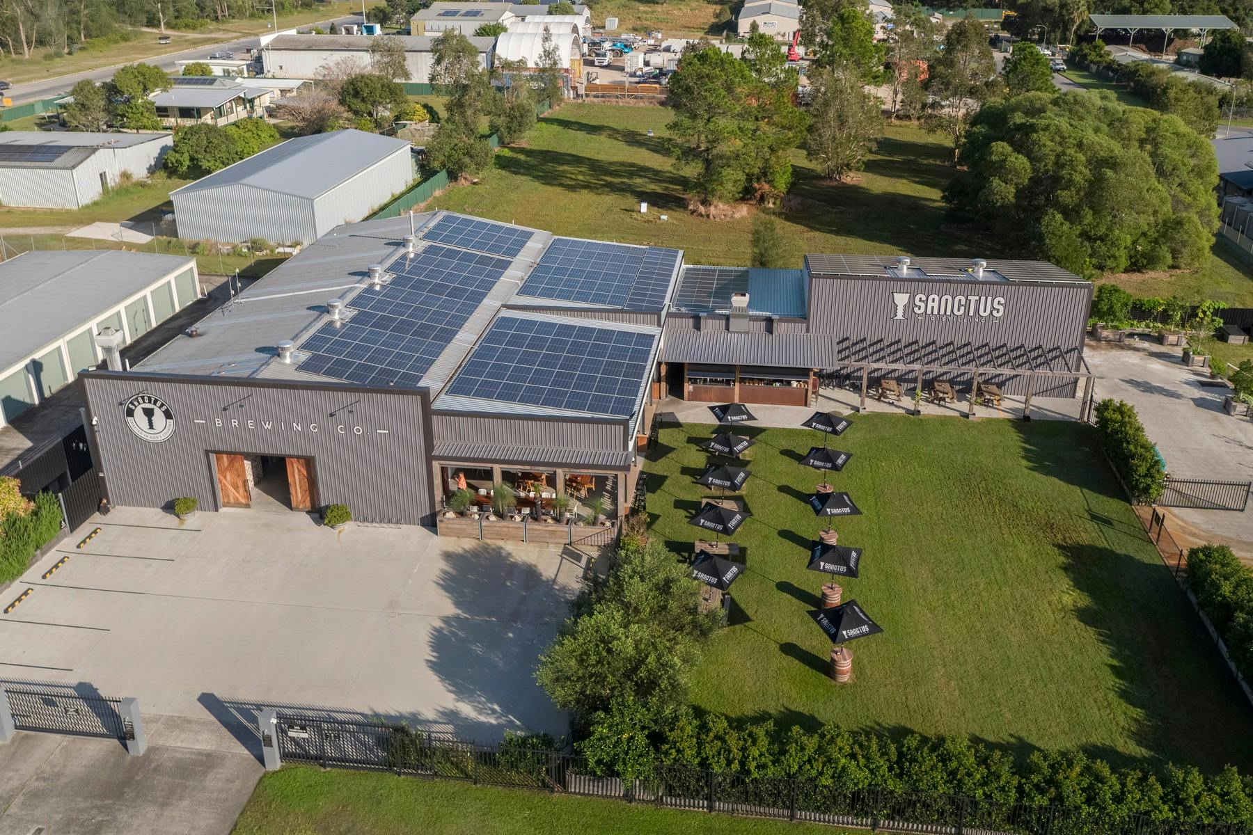 啤酒廠建築的空拍照片，顯示了戶外的草地