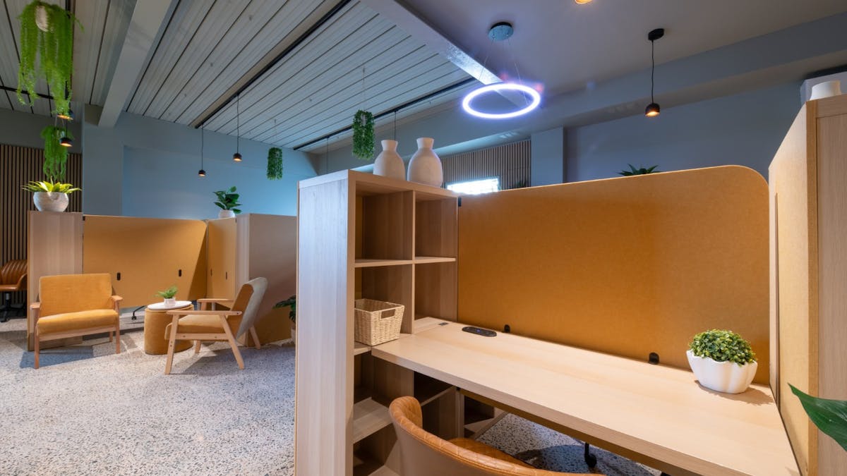 Bright coworking area with hot desks, natural light and minimalist design.