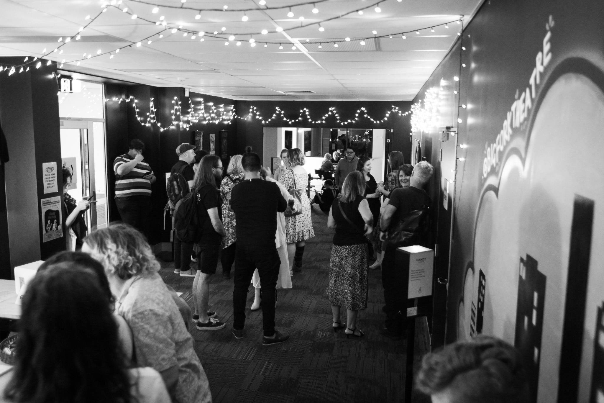 Black and White image of Audience members milling in bar before show