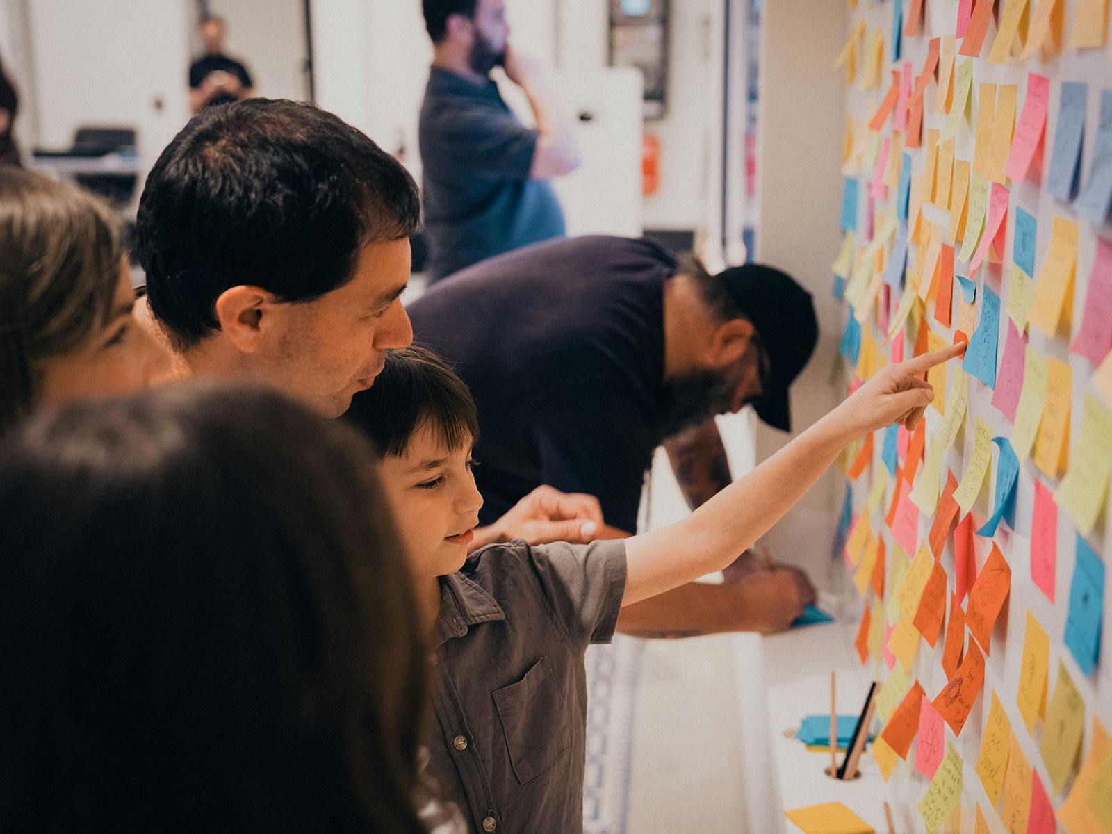 Young family reading the messages of Remembrance inside Anzac Square Memorial Galleries