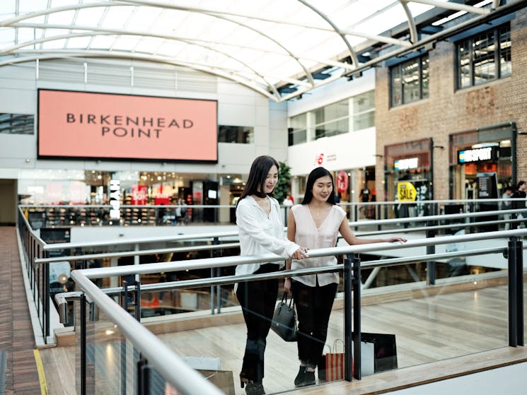 Two ladies at shopping centre looking at shops