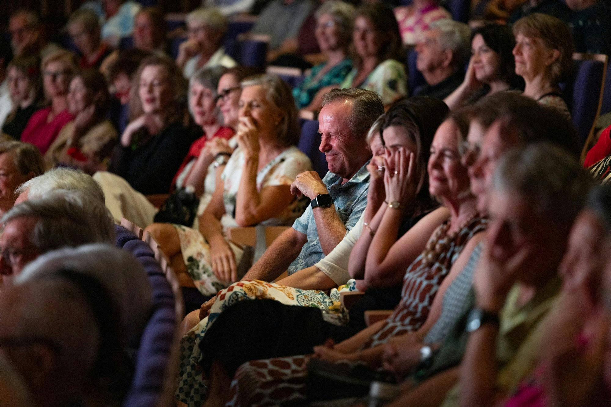 Audience members laughing