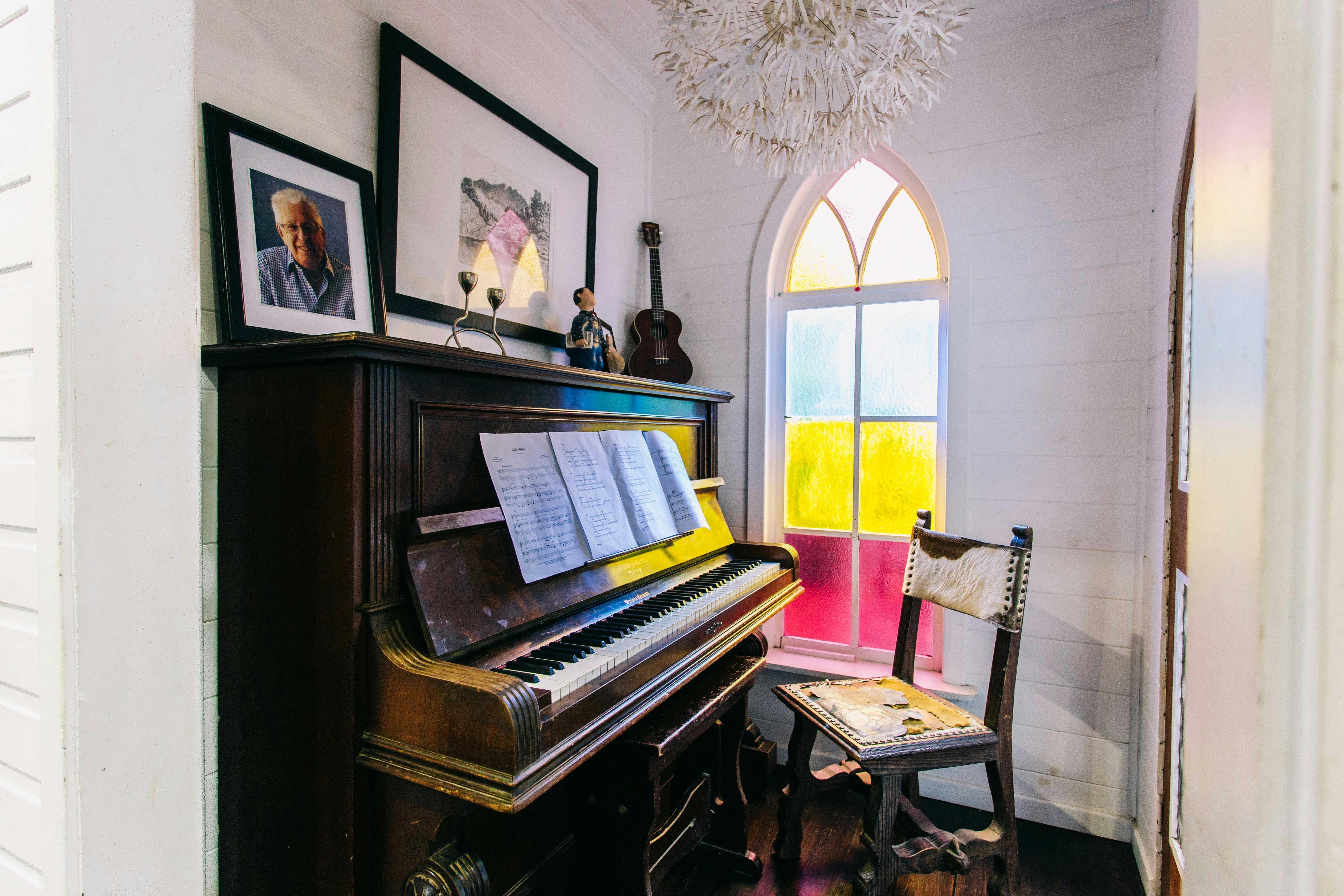 Beautiful old wooden and ivory piano with origiinal stained glass window at the  Converted Church