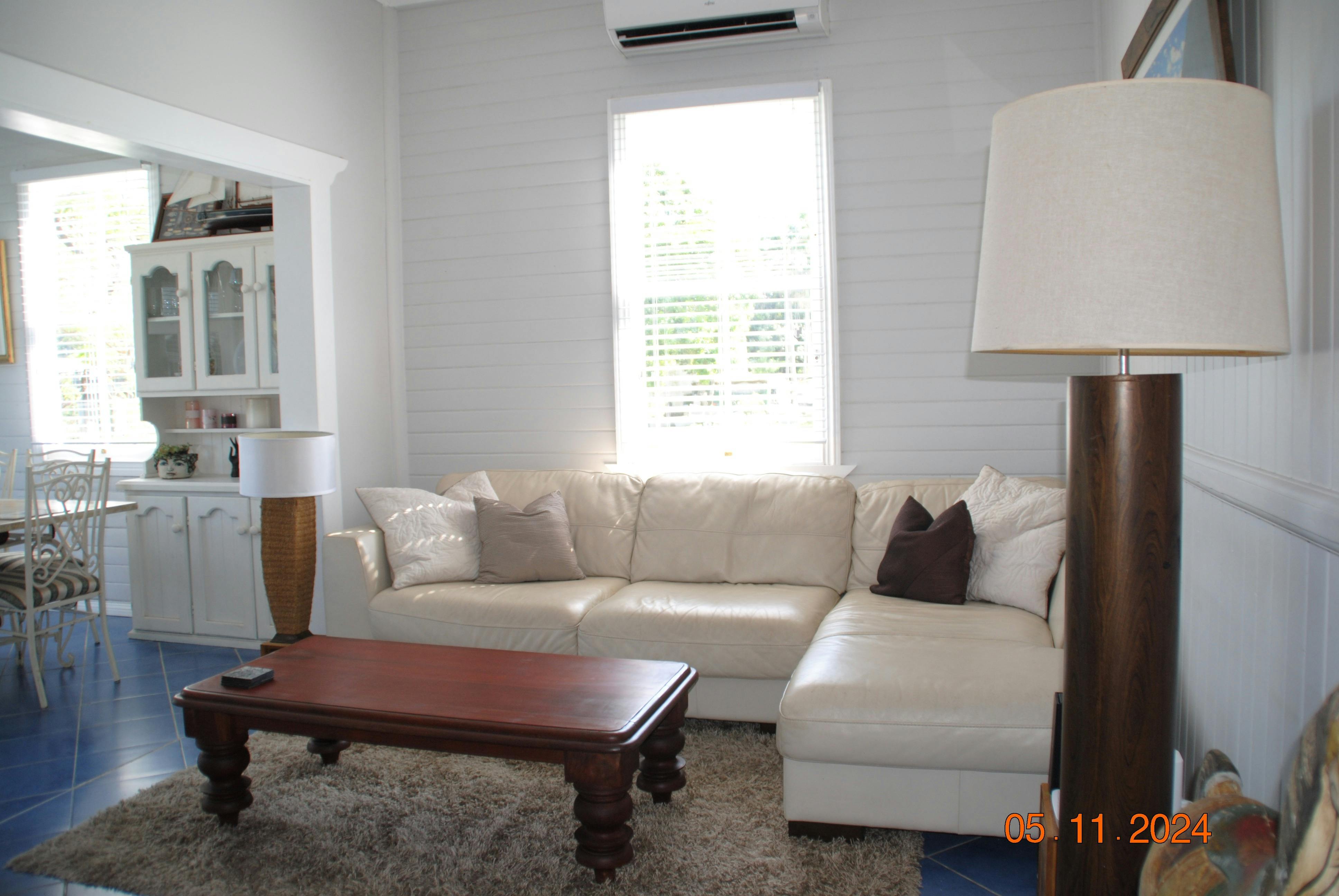 Roomy lounge with leather chaise couch and reverse cycle airconditioner