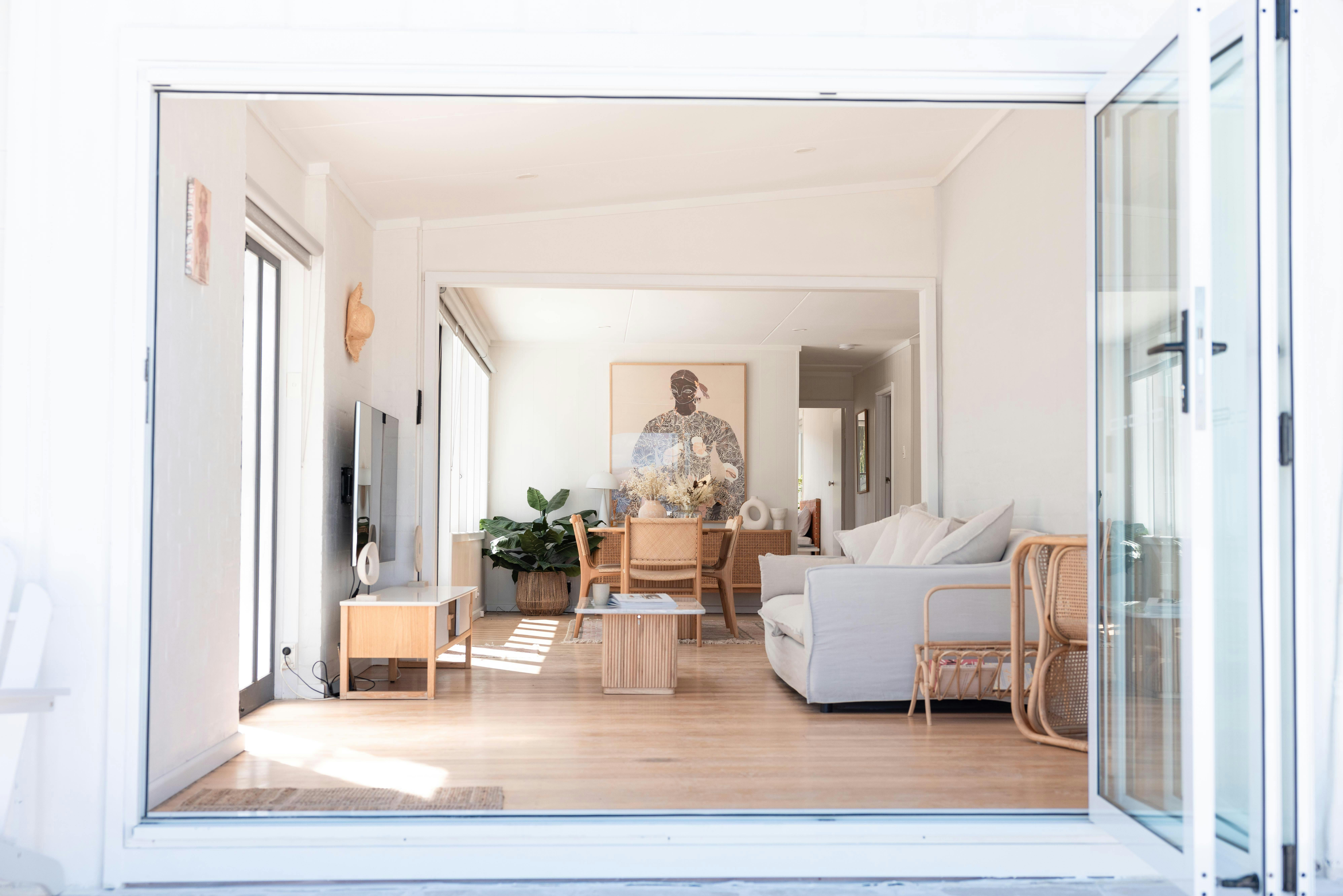 View of a chic, open-concept living and dining area with natural light, neutral tones, and decor