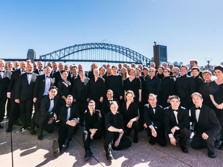 Sydney Gay and Lesbian Choir posing in front of Sydney Harbour Bridge
