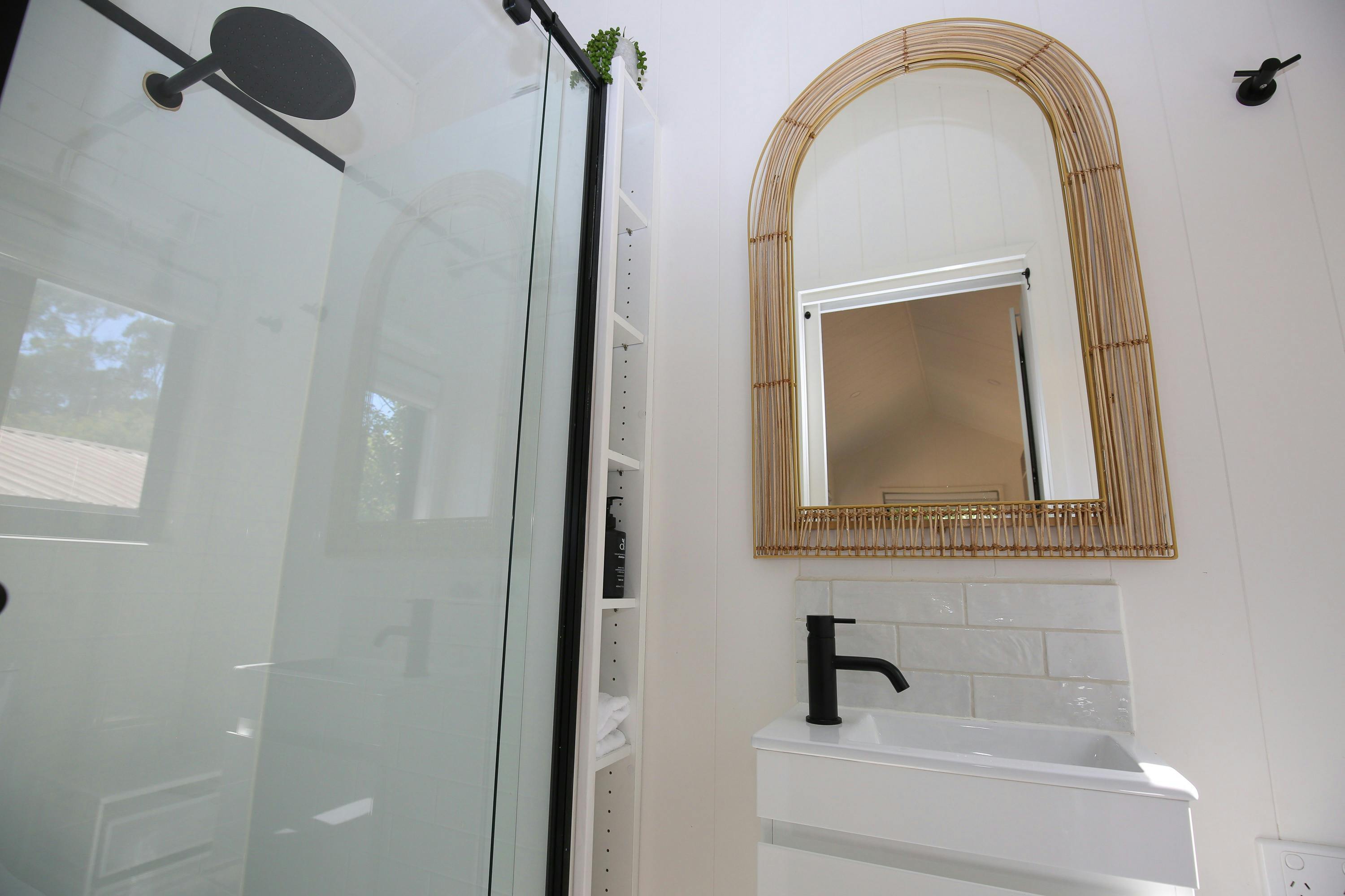 Bathroom at Maple Tiny Home with a sink, mirror and shower