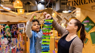 A mother and her child building a tower out of blocks