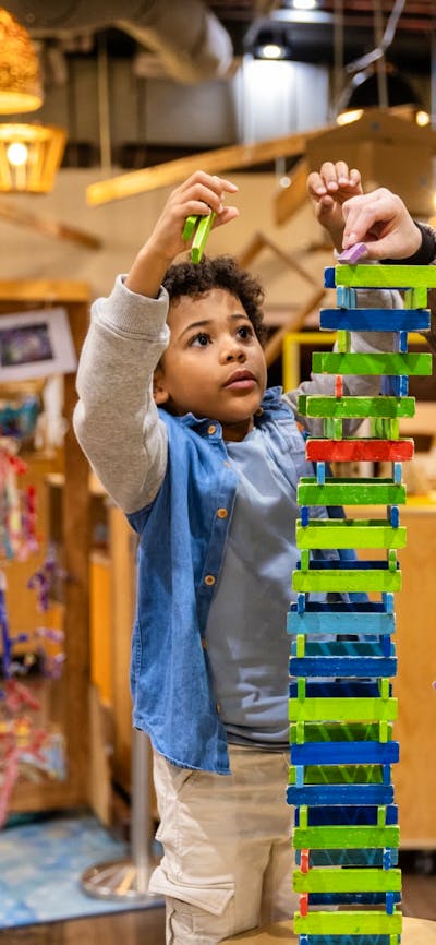 A mother and her child building a tower out of blocks