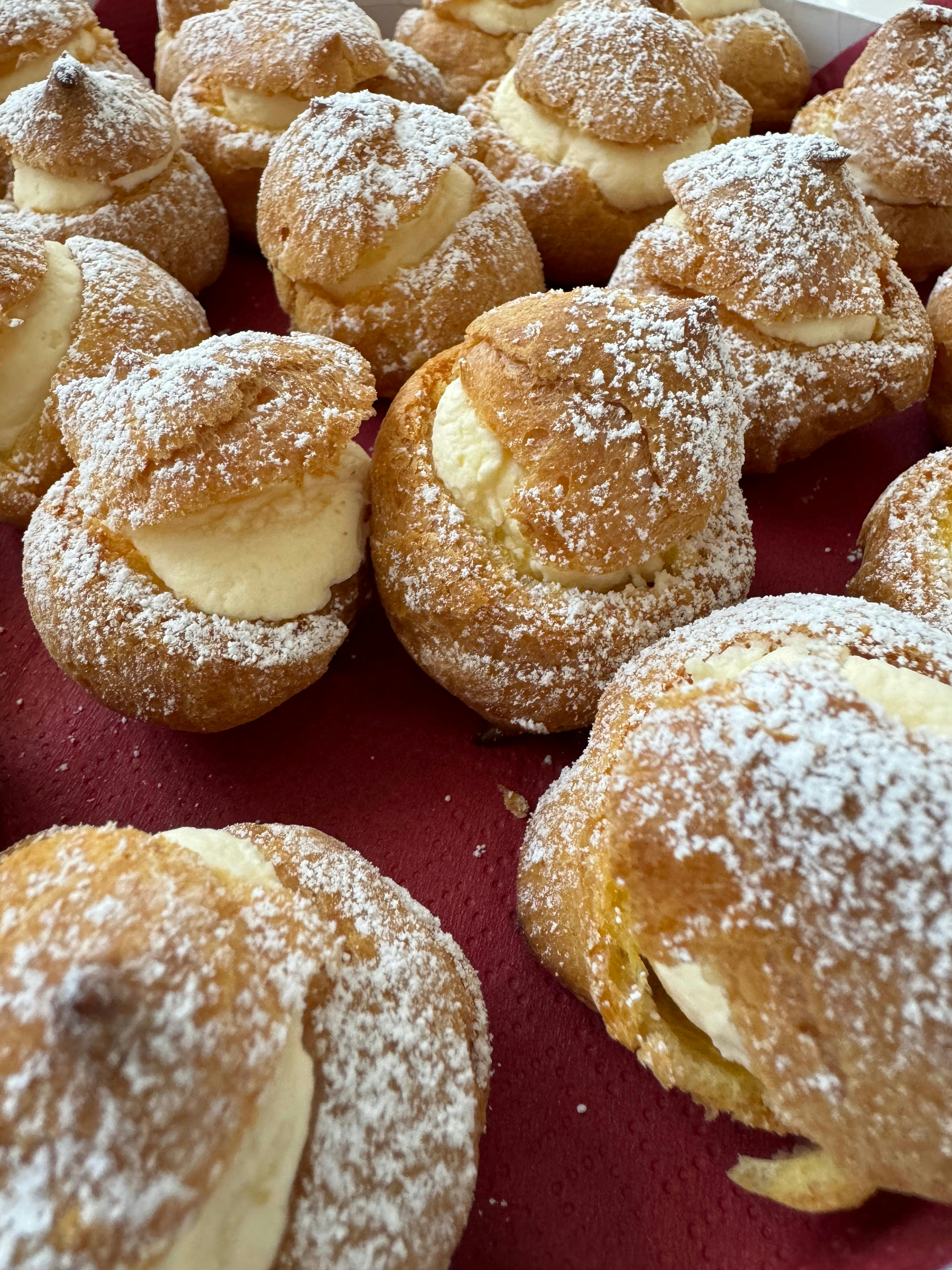 Golden choux pastries filled with cream and dusted with icing sugar