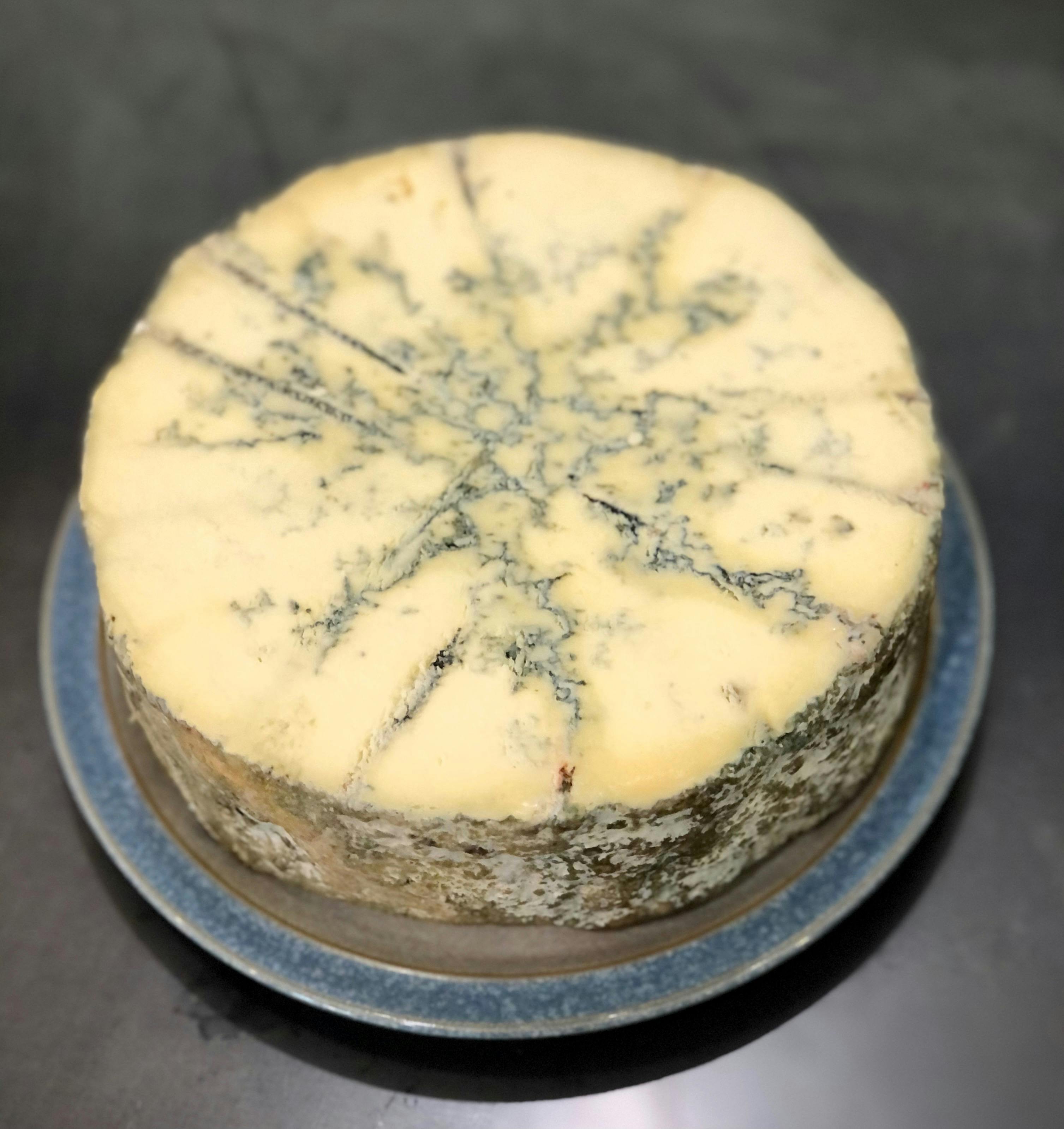 Round of cut blue cheese on plate