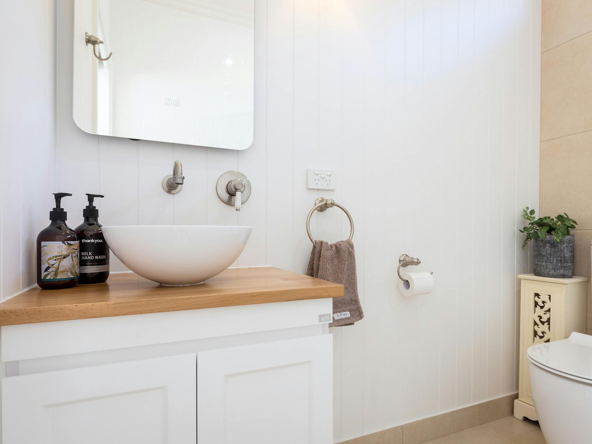 Bathroom, floating vanity, sink on vanity, tap, mirror, hand towel, soap dispensing bottle