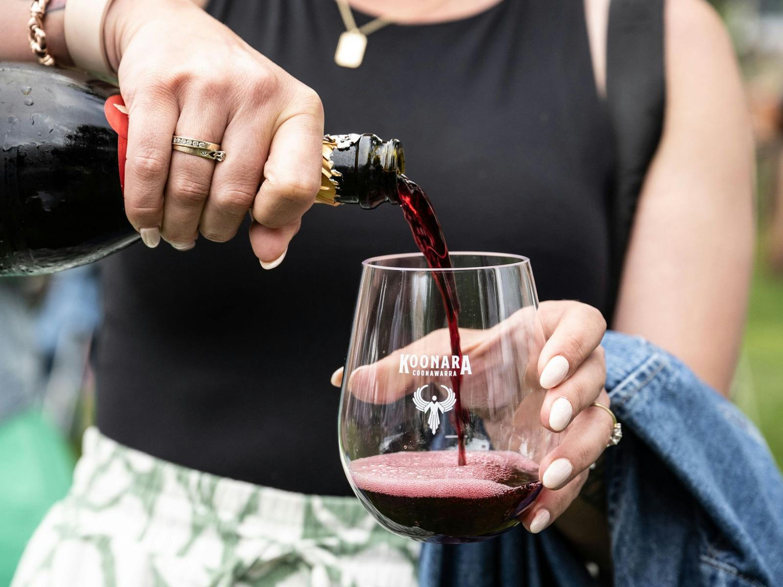 woman holding wine glass and pouring red wine