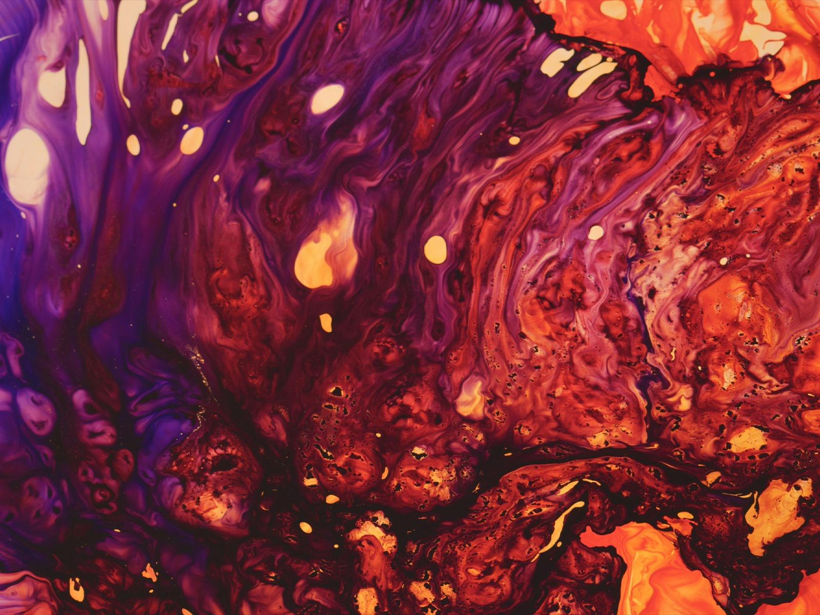 Swirling red, orange and purple liquid creating a vivid abstract pattern.