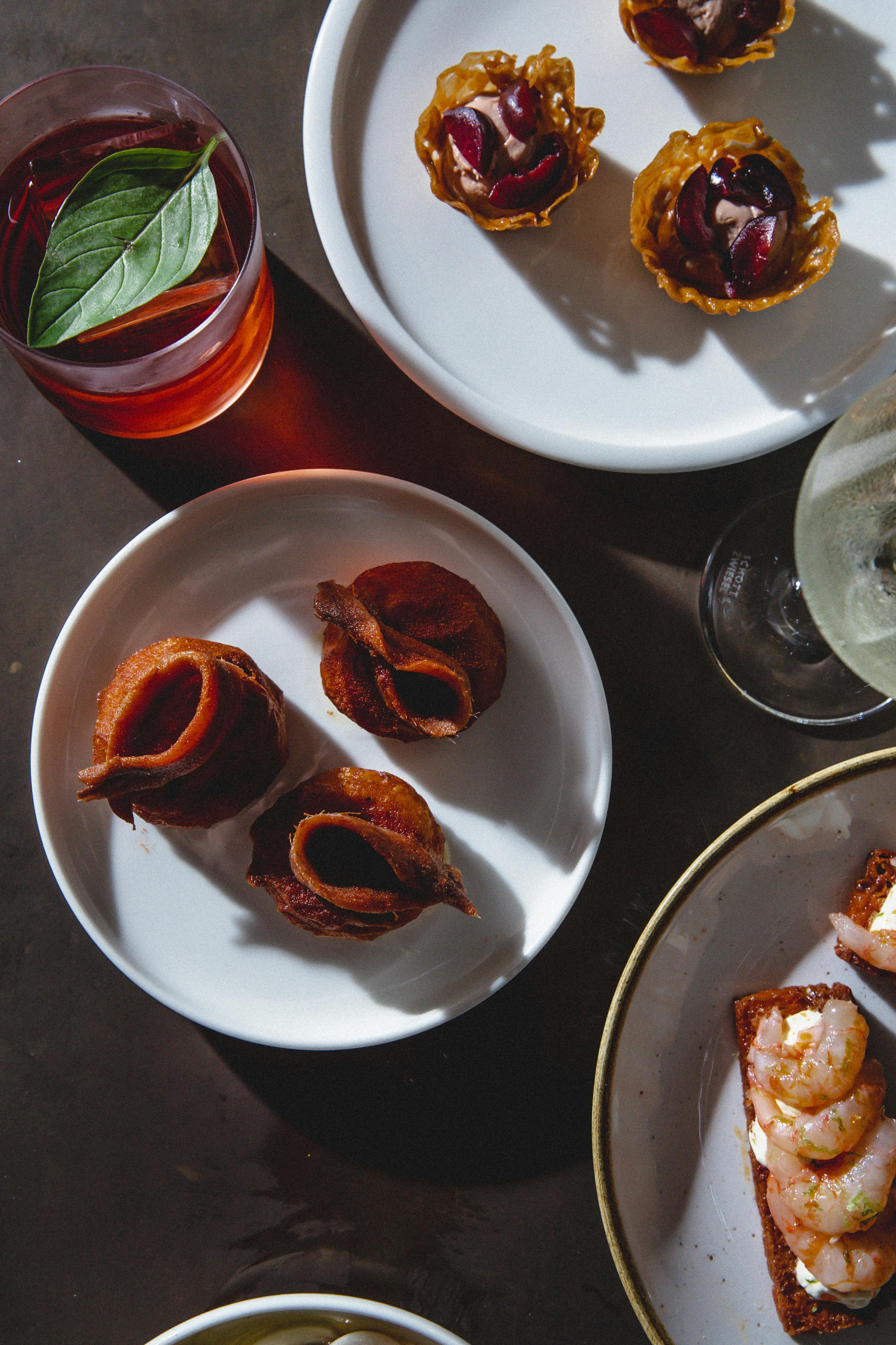 A plate of Manchego-custard filled savoury donuts, topped with anchovies.