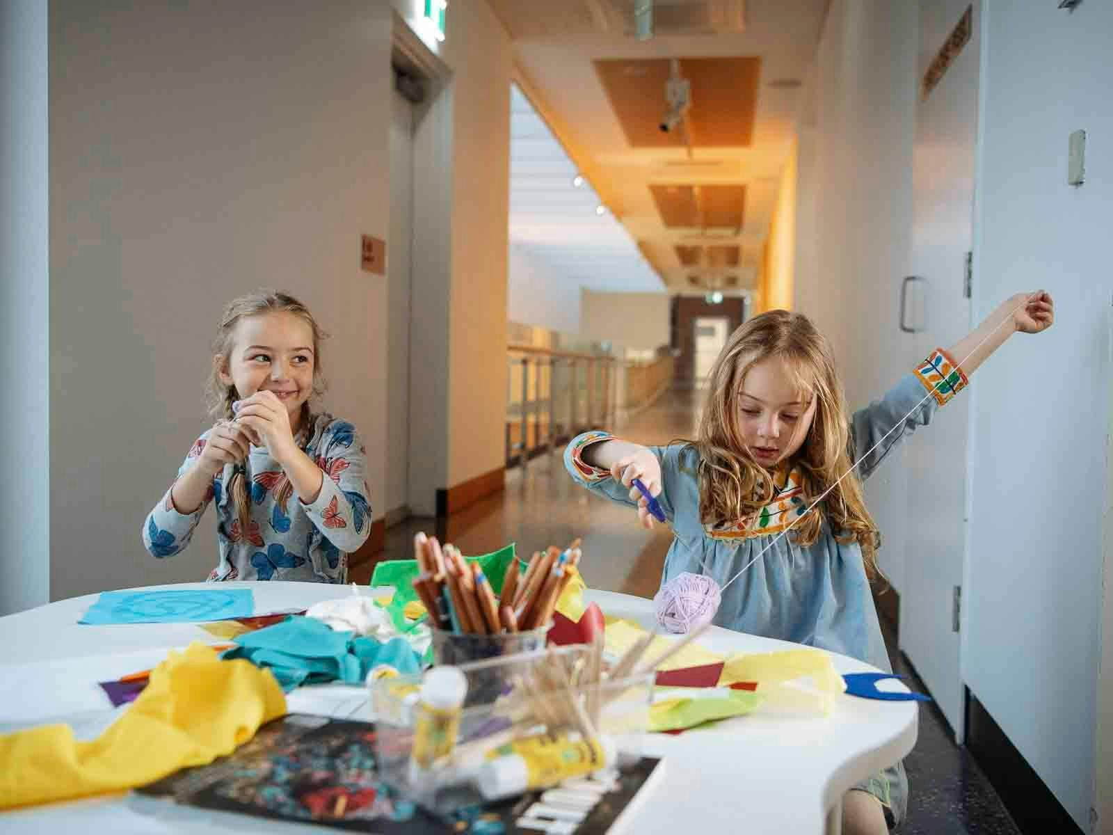Two girls at a craft table enjoying an art activity