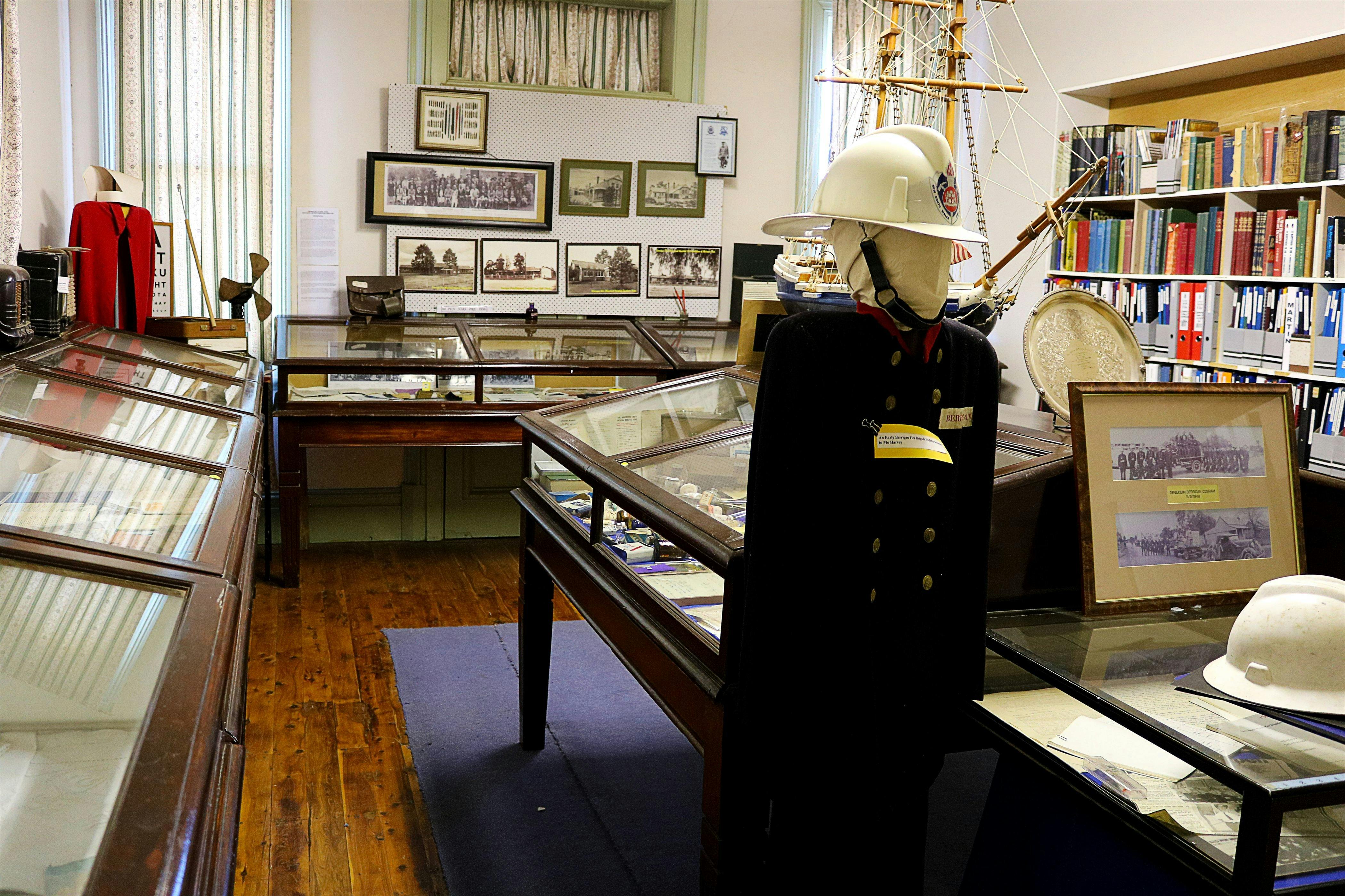 Museum interior with display cabinets, frames on the wall, and mannequin