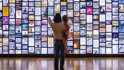 Visitors pointing at interactive digital wall.