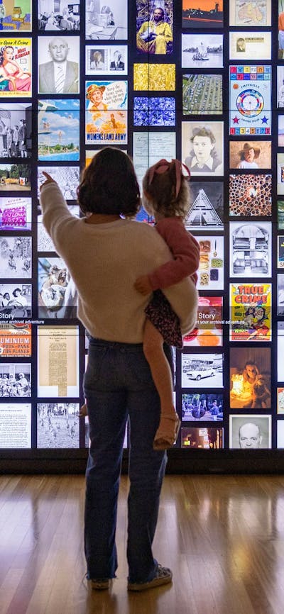 Visitors pointing at interactive digital wall.