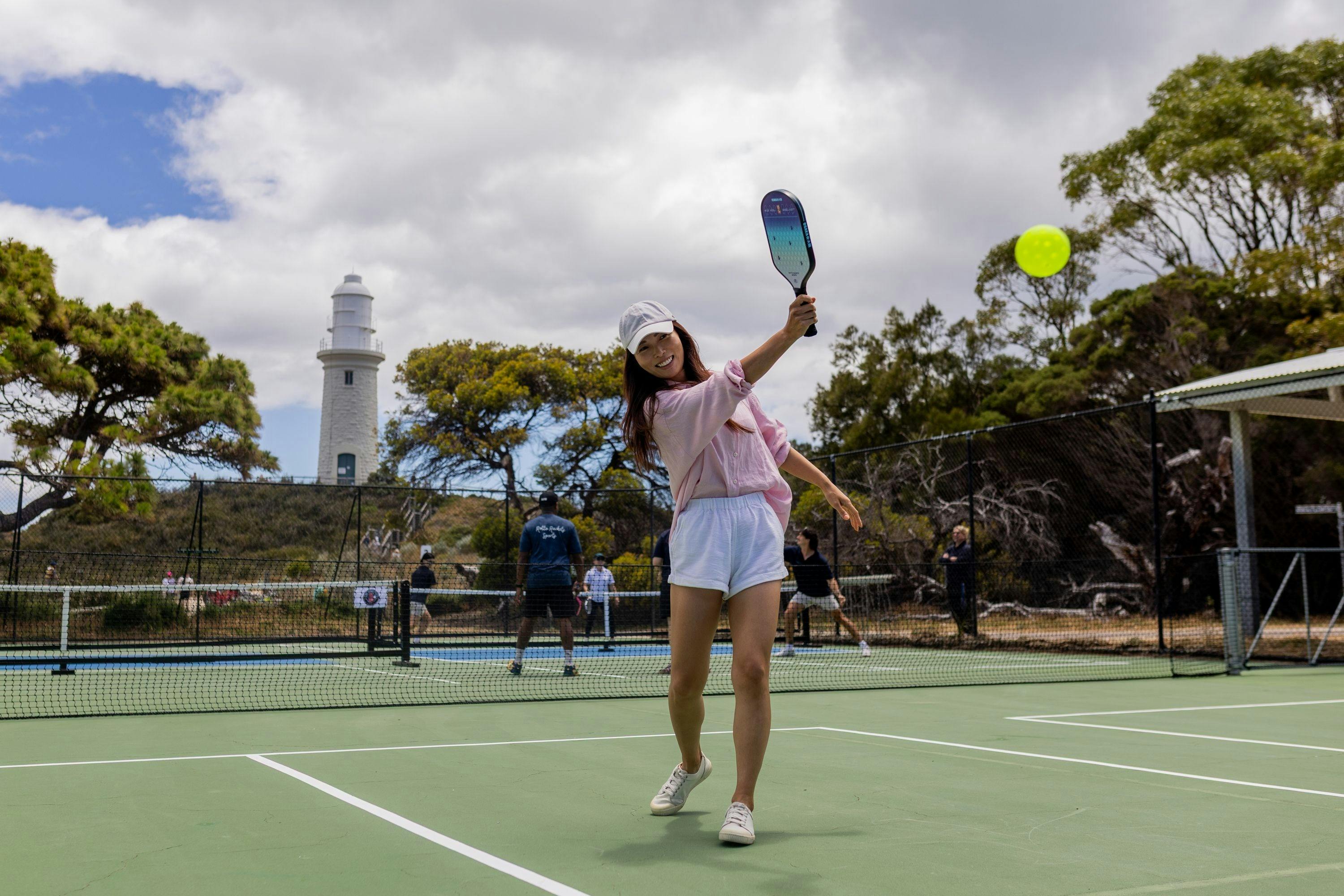 A visitor serving during a game of pickleball at Rotto Rackets Sports on Wadjemup / Rottnest Island.