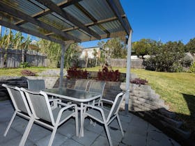 Outdoor dining area with 6 seater dining setting, barbecue and leading out to huge back yard.