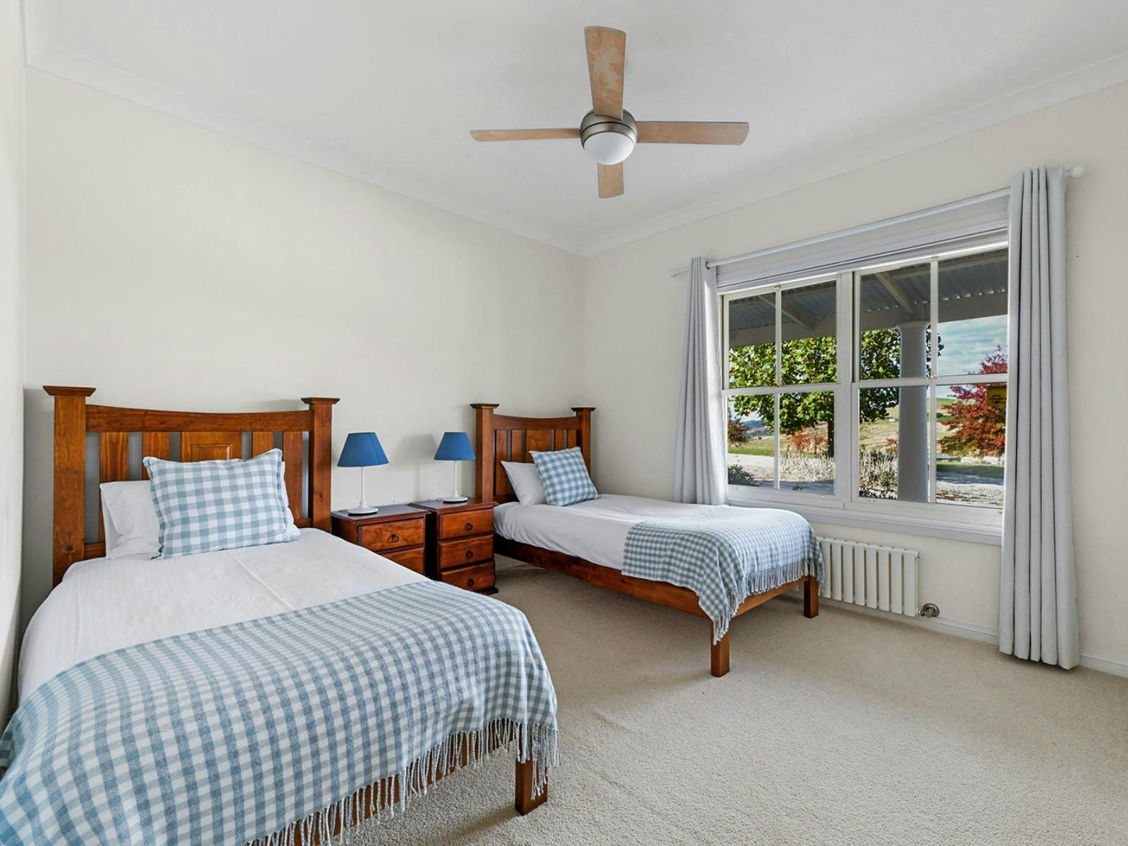 2 wooden single beds with blue and white bedding