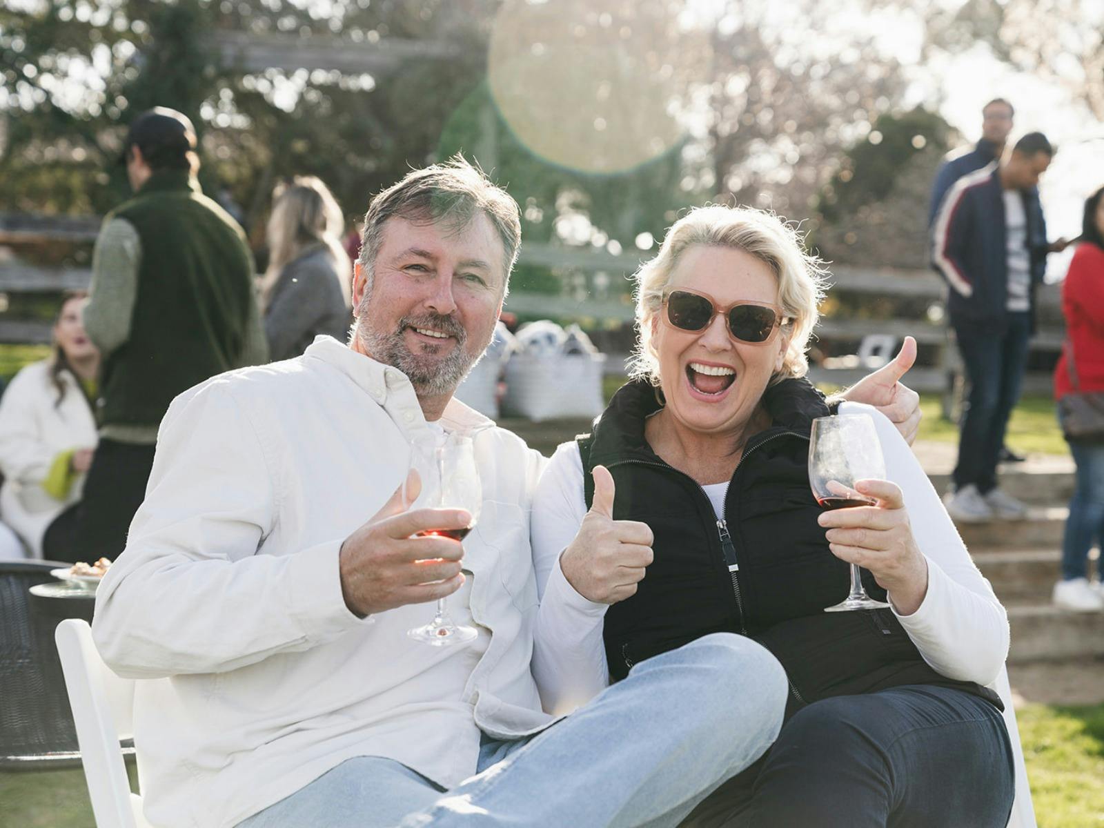 Couple give the camera thumbs up while holding their wine at Stockman's Ridge Wines