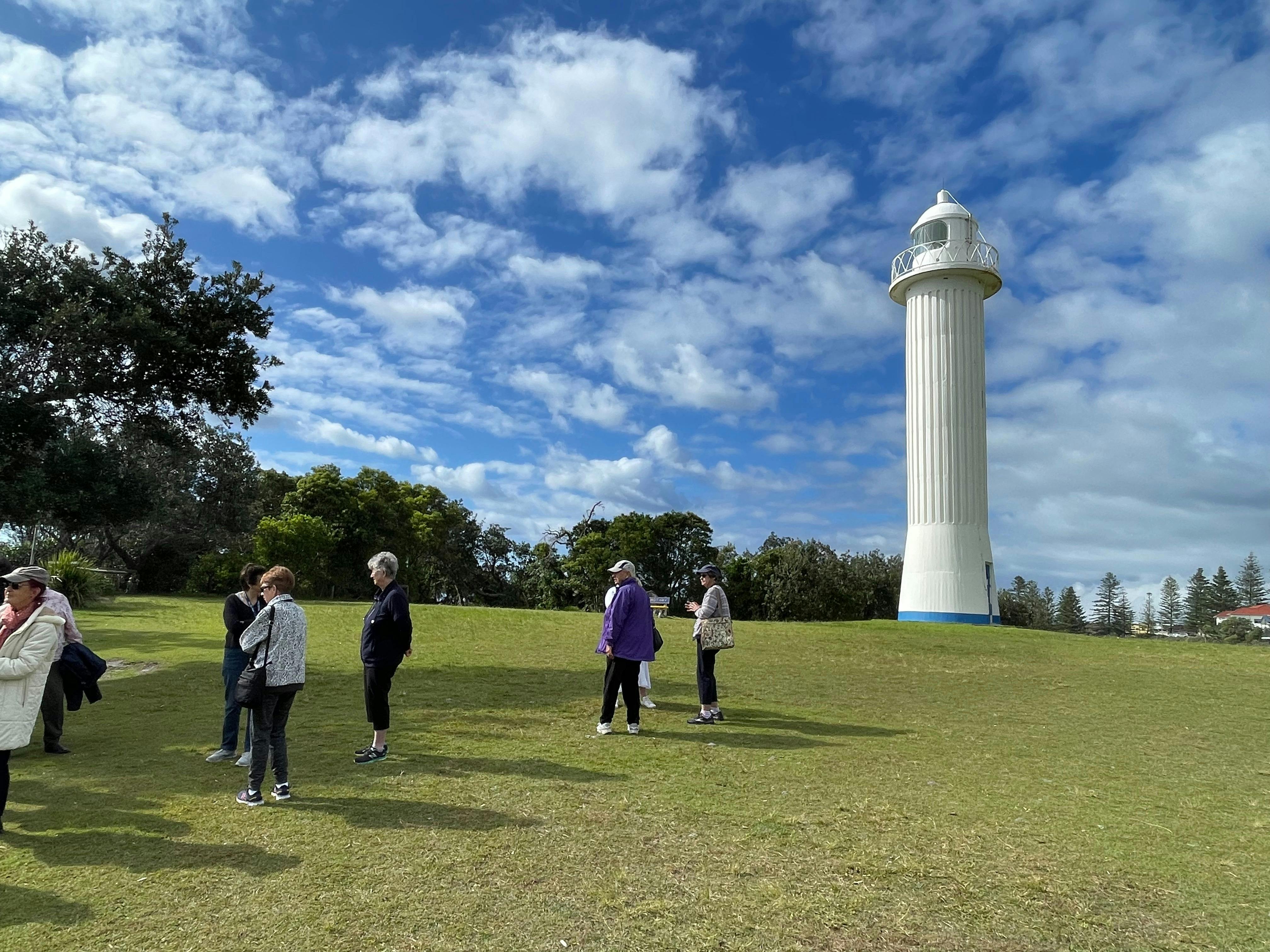 Group standing in front of a white lighthouse at Yamba