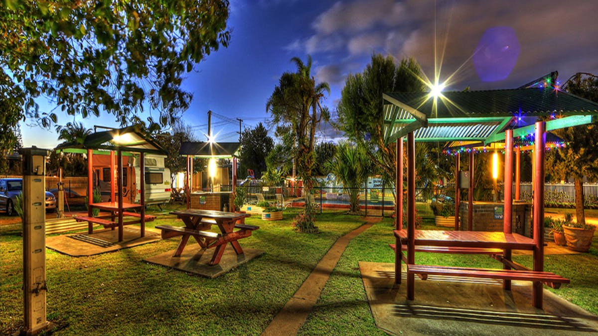 Barbecue Area in tranquil garden setting with covered picnic tables  for guests comfort.