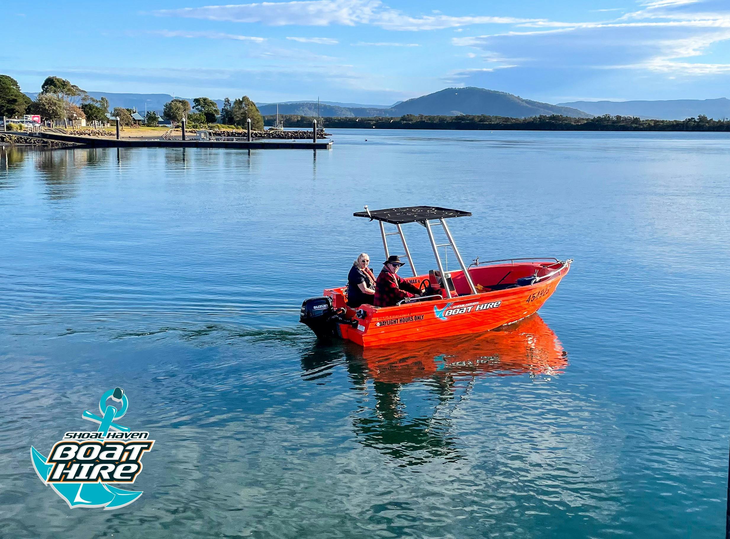 Orange polycraft boat motoring on river