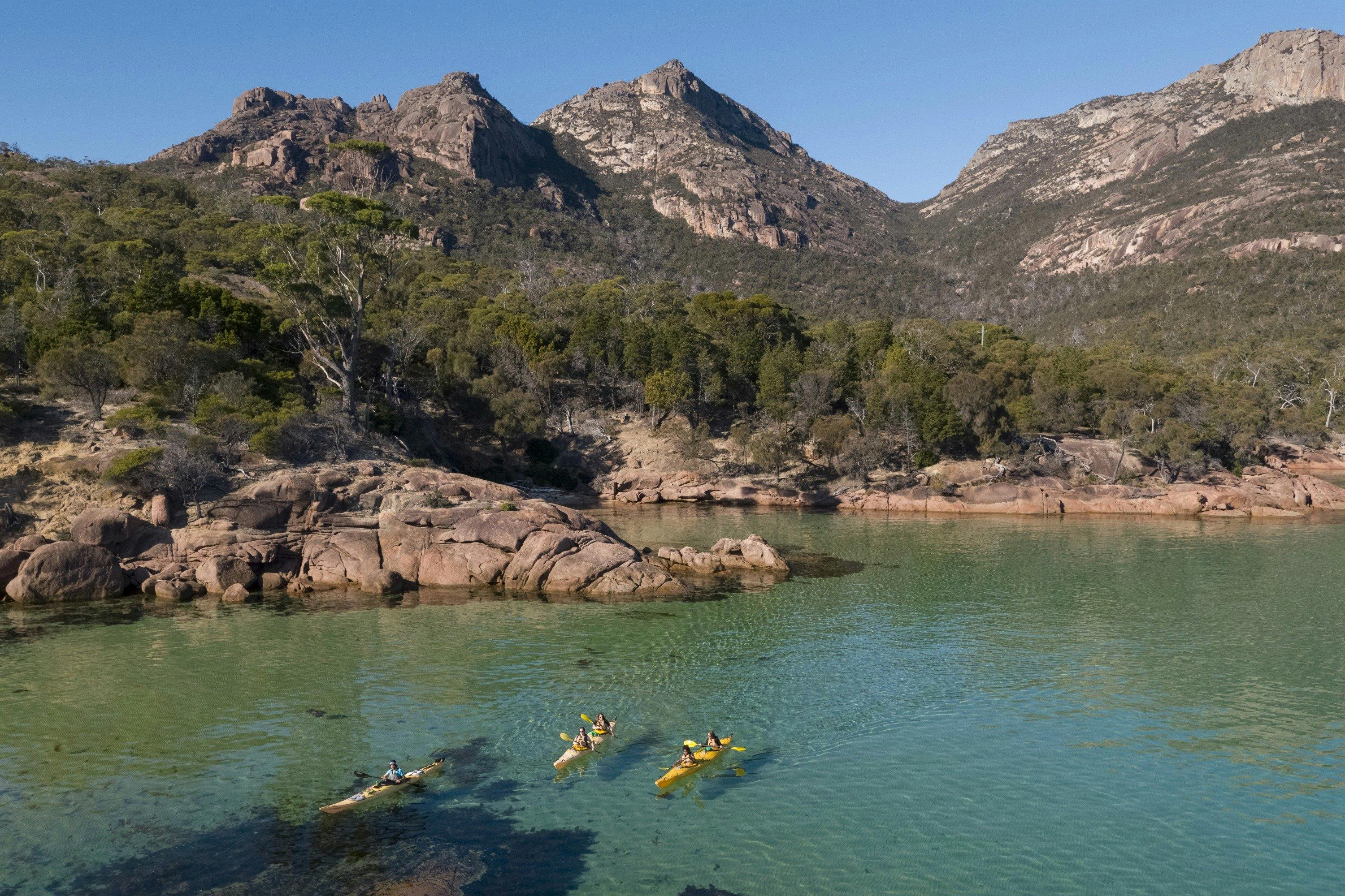 Kayakers paddling into Honeymoon Bay, Freycinet National Park.