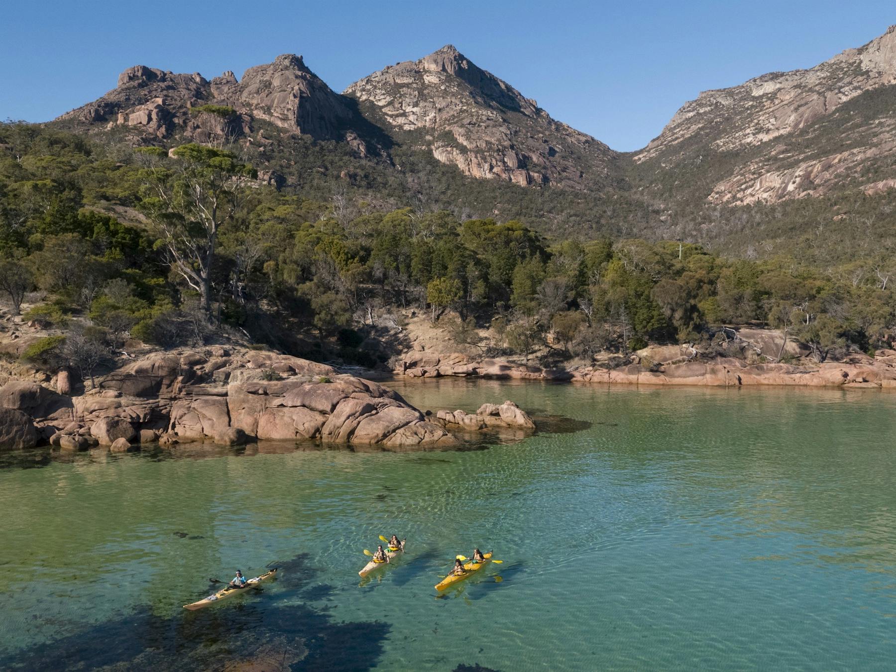 Kayakers paddling into Honeymoon Bay, Freycinet National Park.