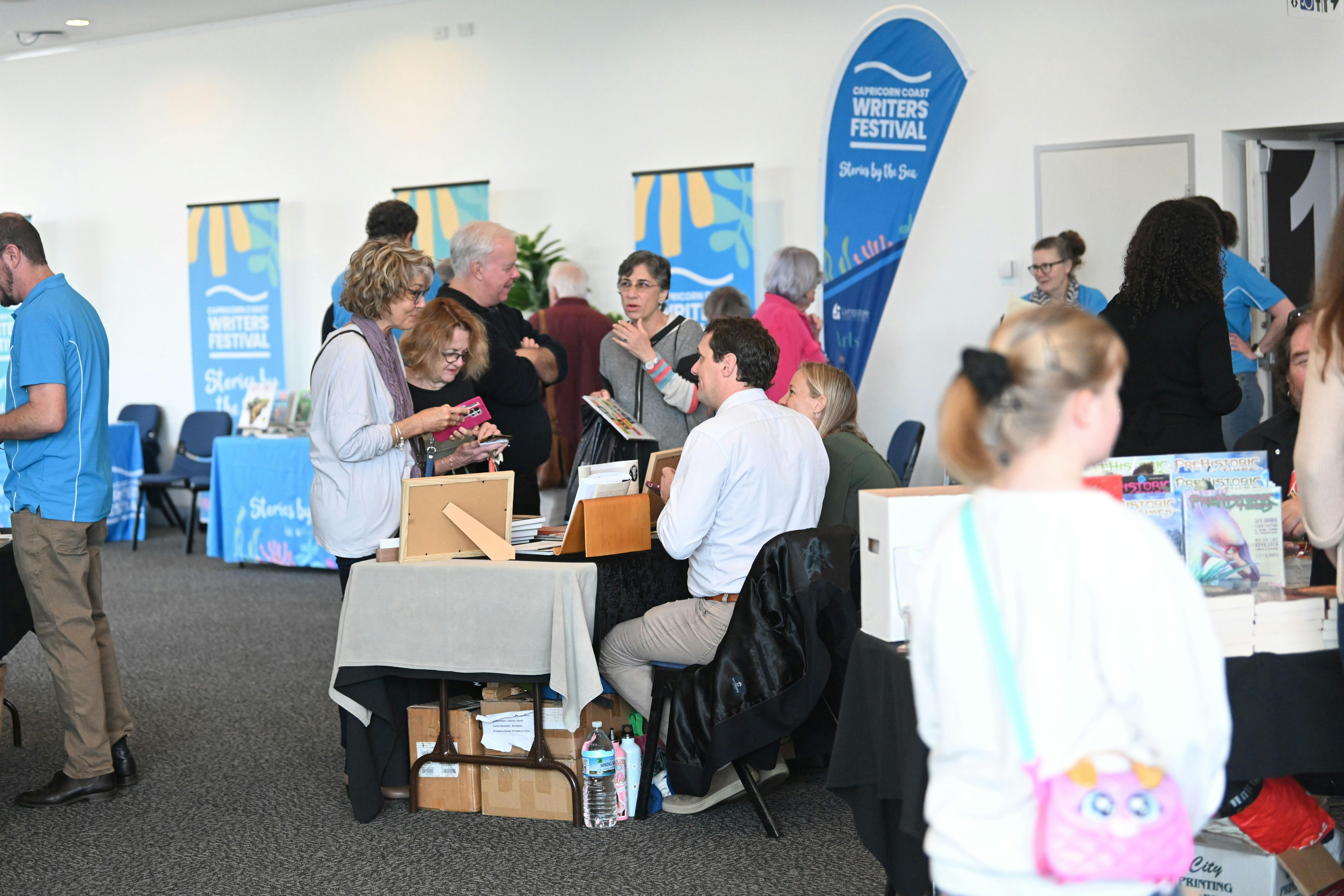 participants talking with authors who are signing copies of their book. Conversational atmosphere