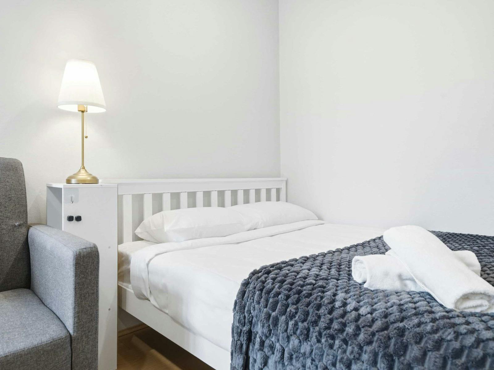 Comfortable double bed with soft linens and accent throw for added comfort.