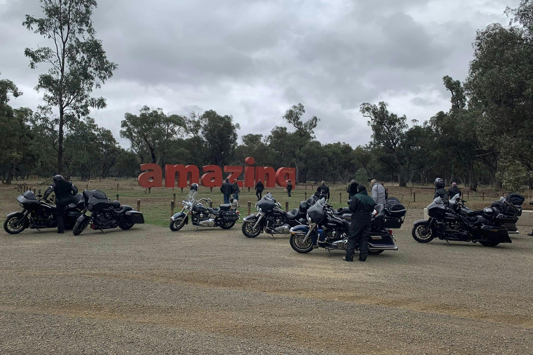 Art installation featuring the word amazing in big red letters with motorcycles in the foreground