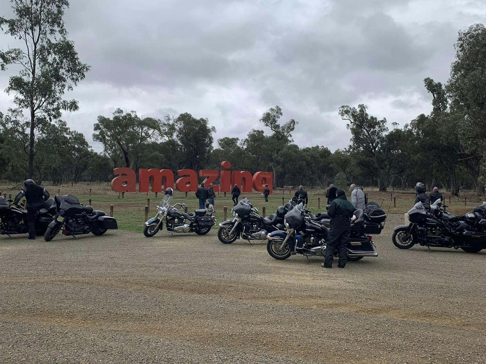 Art installation featuring the word amazing in big red letters with motorcycles in the foreground