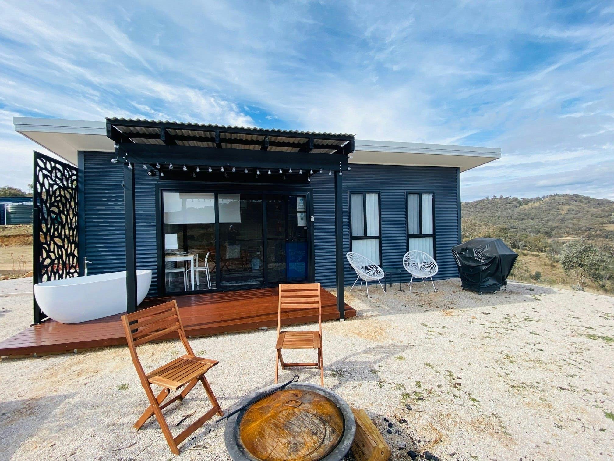Rose Quartz cabin exterior with outdoor chairs, fire pit, BBQ, deck, and outdoor tub