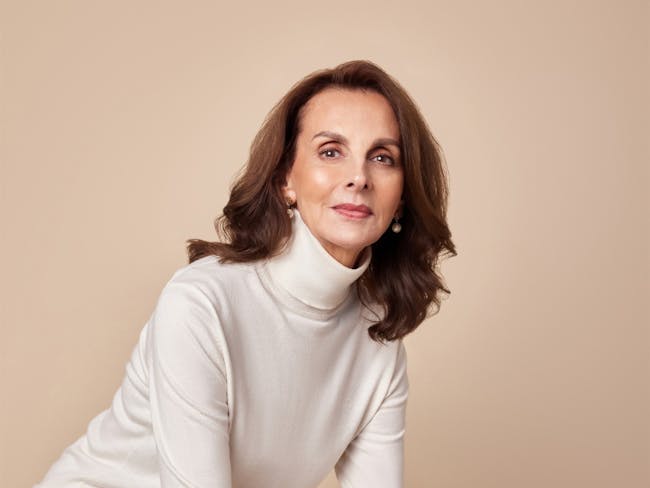 A brunette woman in a white turtleneck jumper.