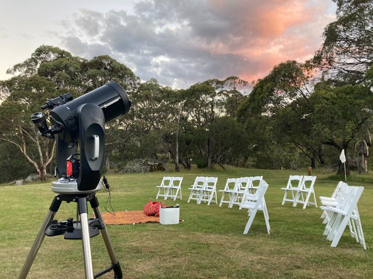Stargazing site with chairs and telescope ready for guests to arrive